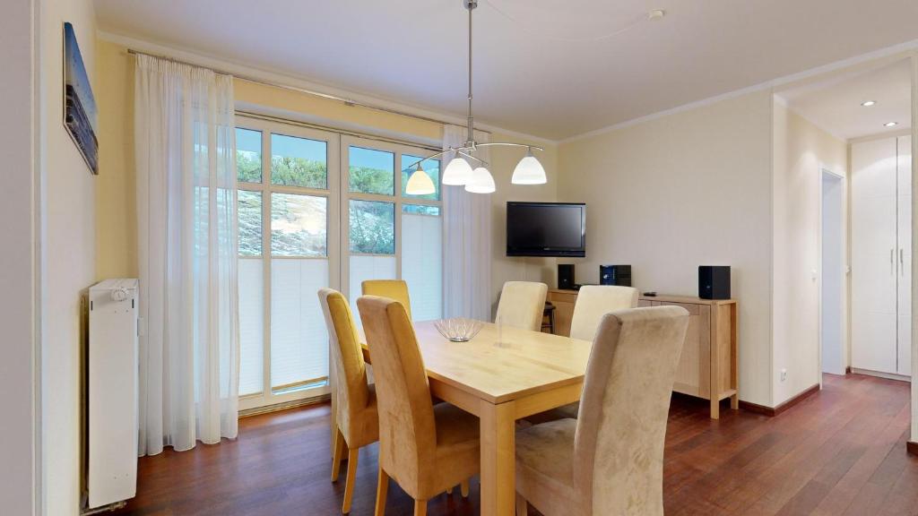 a dining room with a wooden table and chairs at strandnahe FeWo mit 2 Schlafzimmern und Terrasse oder Balkon, Caspar David, Binz in Binz