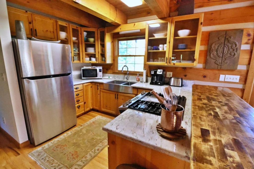 a kitchen with a stainless steel refrigerator and wooden cabinets at The Oakes in Cherokee