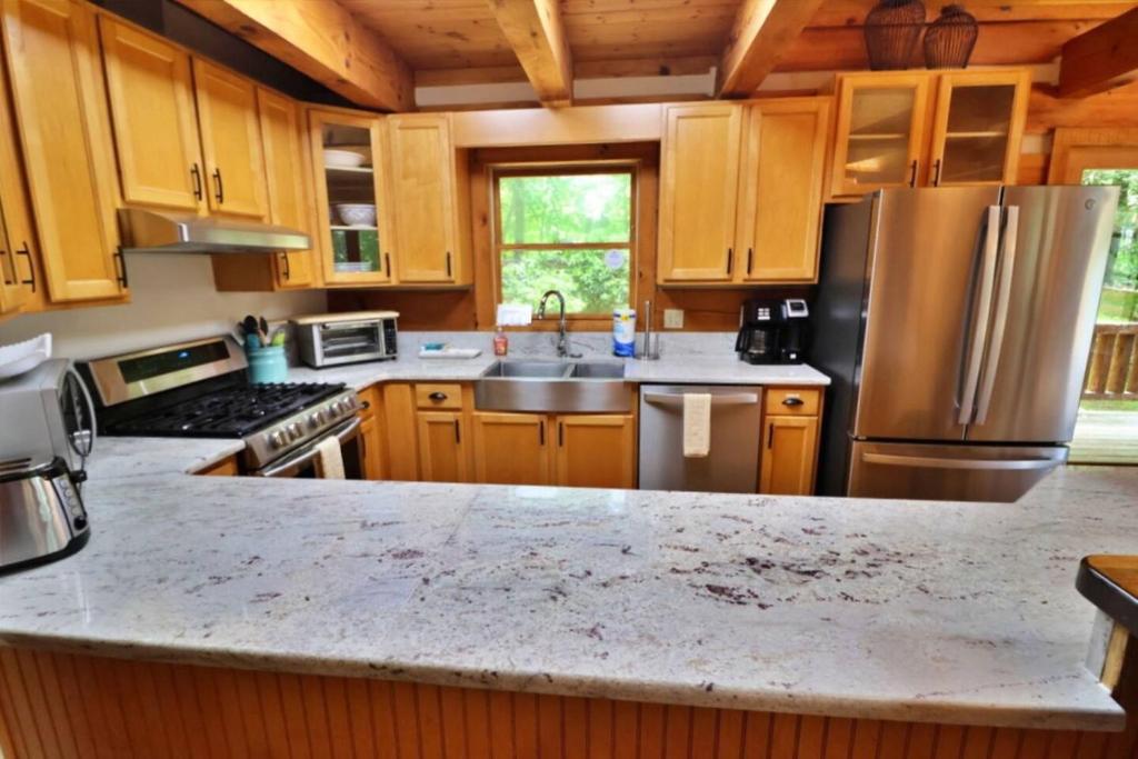 a kitchen with wooden cabinets and a stainless steel refrigerator at The Hilltop in Cherokee
