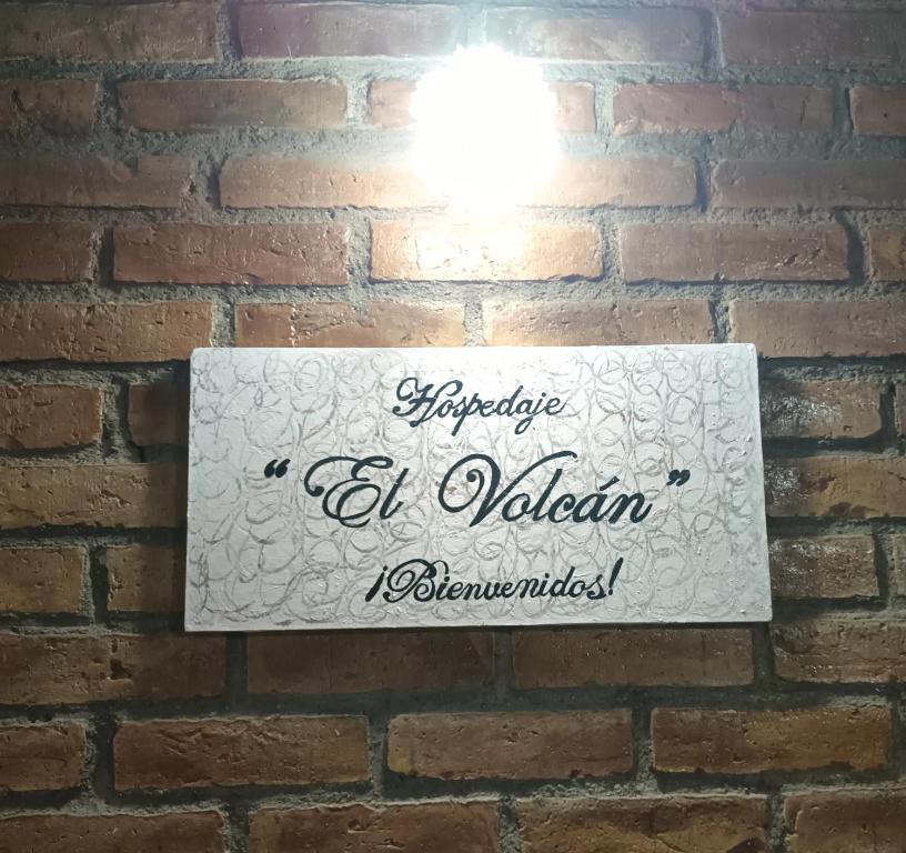a sign on a brick wall with a light on it at El Volcán in Tupungato
