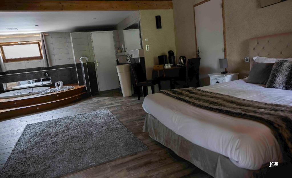a hotel room with a bed and a bathroom at Le Petit courault in Pamproux