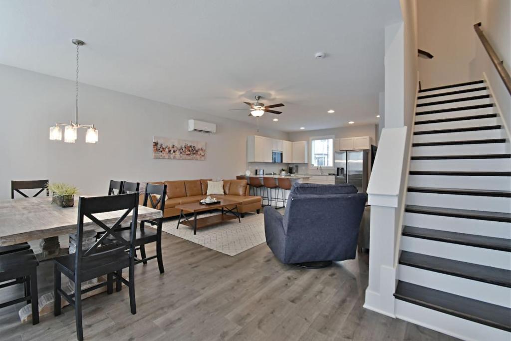 a living room and dining room with a staircase in a house at Rooftop Balcony with River View in SoKnox in Knoxville