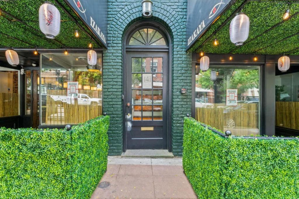 a store front with a black door and green bricks at The Nama Retreat 201 - Renovated Downtown Loft near Gay St | Walk Everywhere in Knoxville