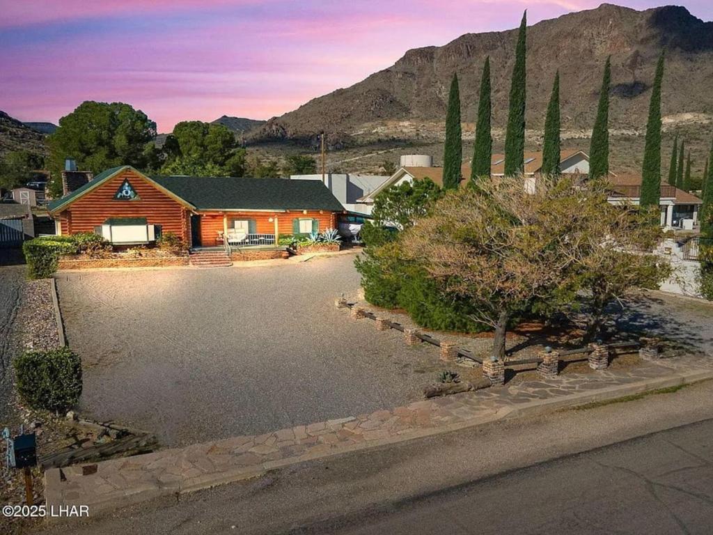a house with a driveway in front of a mountain at Kingman Cabin in Kingman