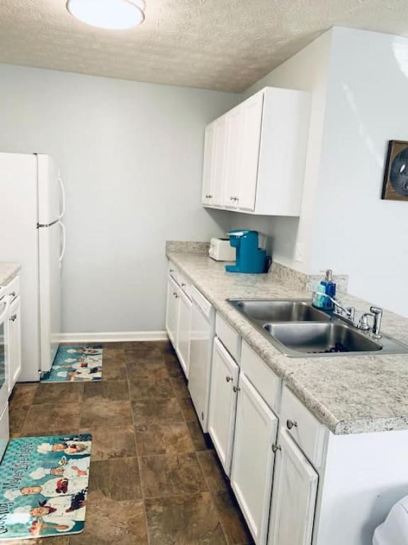 a kitchen with white cabinets and a sink at Covington Station Escape in Lithonia