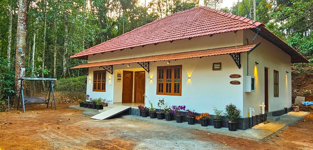 a small house in the middle of a forest at Mamoksha Riverdale in Padinjarathara