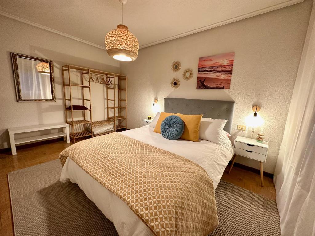 a bedroom with a large bed with yellow and blue pillows at Villa Yoli, céntrico con plaza de garaje in Avilés