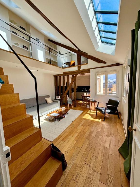 a living room with stairs and a skylight at Duplex château de Versailles - 30 min de Paris in Versailles