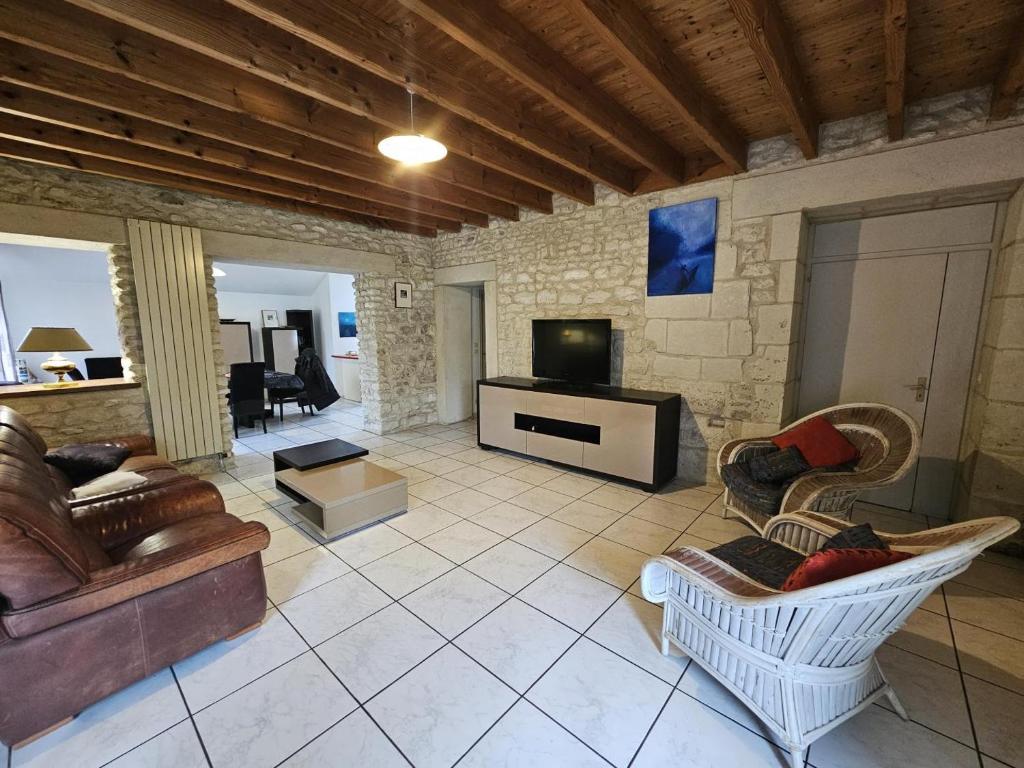 a living room with a couch and a tv at Le pin de la tour in Sossais