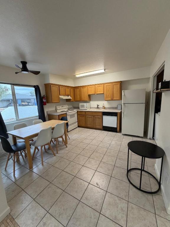 a kitchen with a table and chairs and a refrigerator at Spring Training Special Comfy 3 Bedroom in Phoenix
