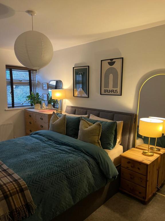 a bedroom with a bed with a blue comforter at Room at Wallington Green for professionals, free parking, near station, 30 min to London Bridge, 27 min to LDN Victoria in Wallington