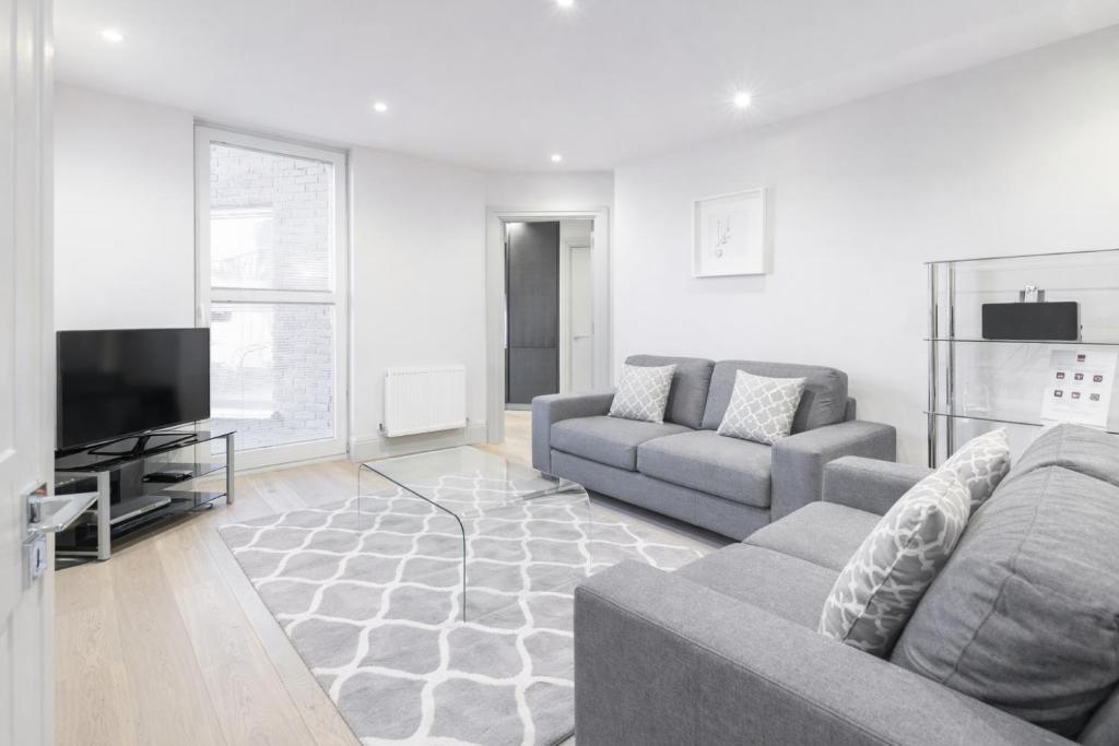 a living room with couches and a flat screen tv at Roomspace Serviced Apartments - The Quadrant in Richmond upon Thames