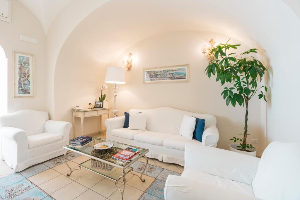 a living room with two white couches and a table at Villa La Tartana in Positano