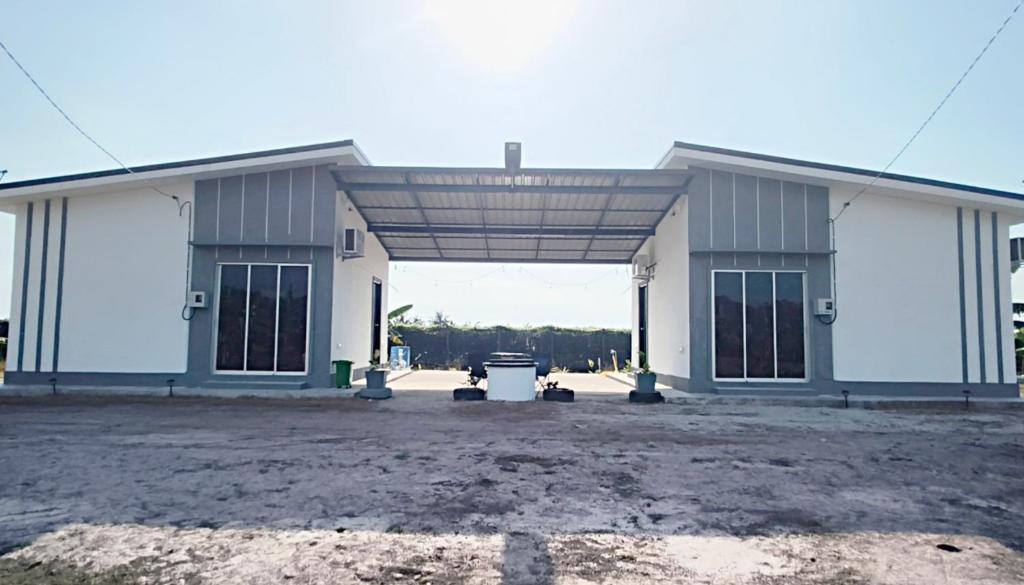 a large white building with a large garage at White House Villa in Sekinchan