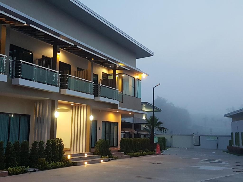 a building with a parking lot in front of it at Smile Resort Thungsong in Thung Song