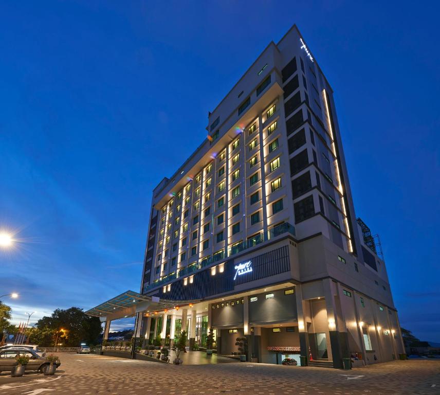 a tall building with lights on in a street at Purest Hotel Sungai Petani in Sungai Petani