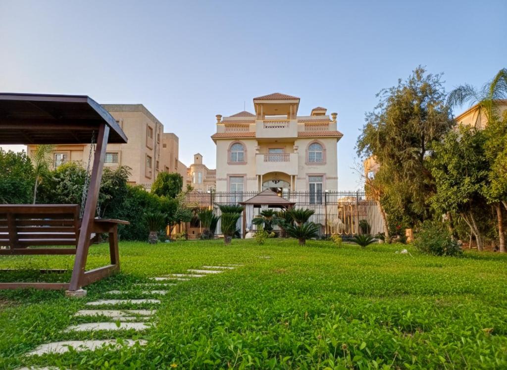 a large house with a grass yard in front of it at قصر فنيسيا 6غرف للإيجار ViP Vienice Palace luxury in 6th Of October