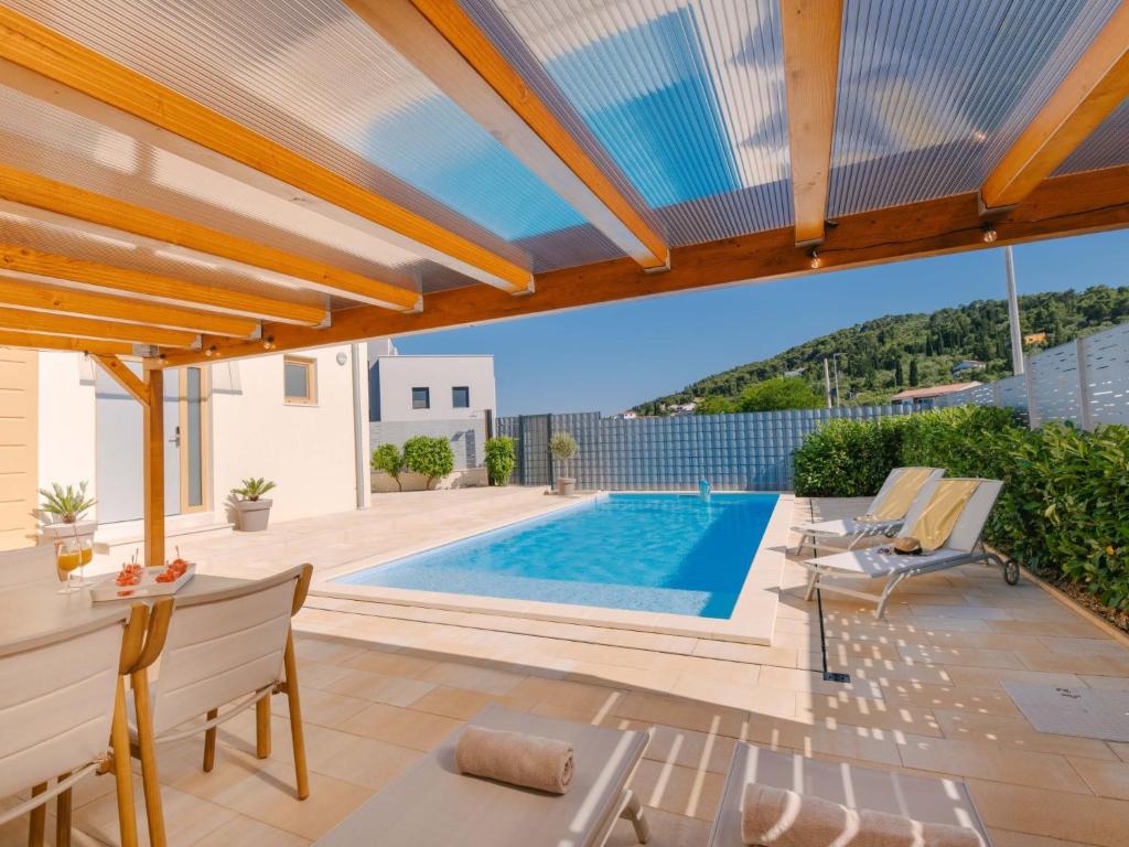 a patio with a swimming pool and a house at Holiday Home A'more Preko Ferienhaus in Preko Insel Ugljan by Interhome in Preko
