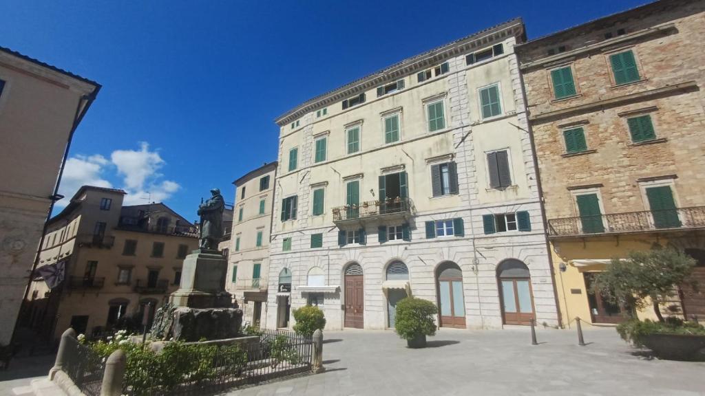 a large building with a statue in front of it at la Ciccinina in Sarteano