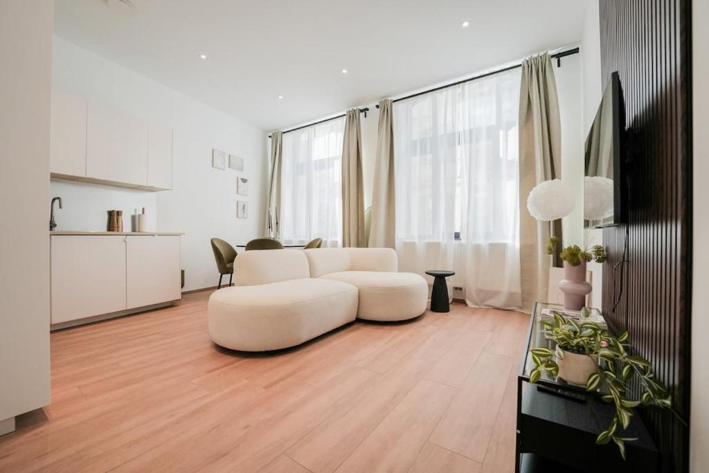 a living room with a white couch and a table at Appartement en plein centre-ville in Liège