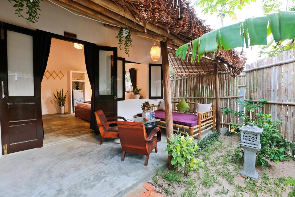 een buitenterras met een tafel en stoelen bij An Bang Purple Homestay in Hội An