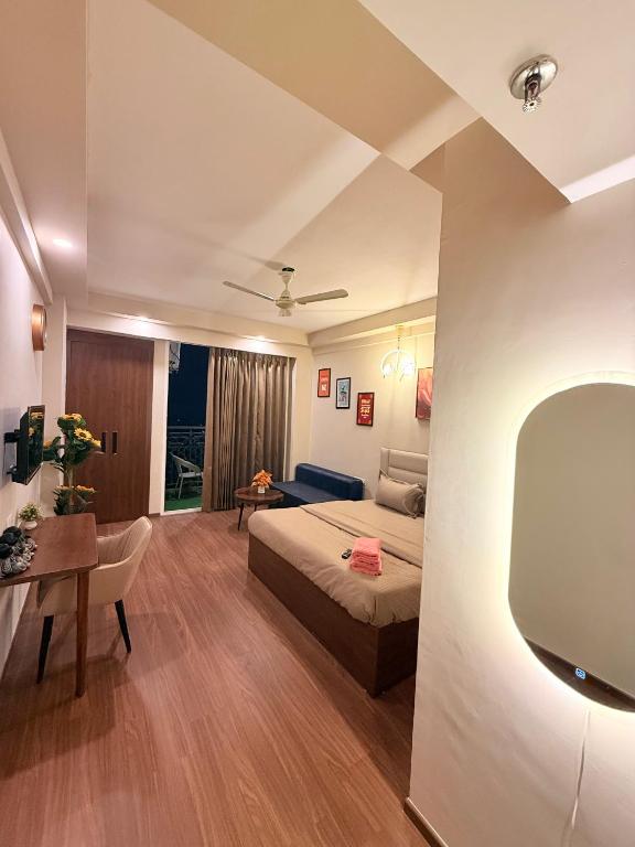 a room with a bed and a desk and a tv at Hazelnut -Expo India centre in Greater Noida