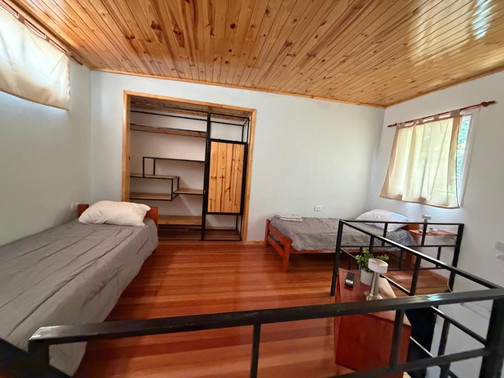a room with two beds and a wooden ceiling at Elvira in Estación Circunvalación