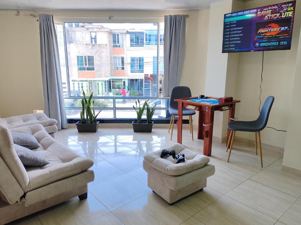a living room with couches and a tv and a table at Apartamento familiar en zona norte de Tunja, cerca a Viva, con parking in Tunja