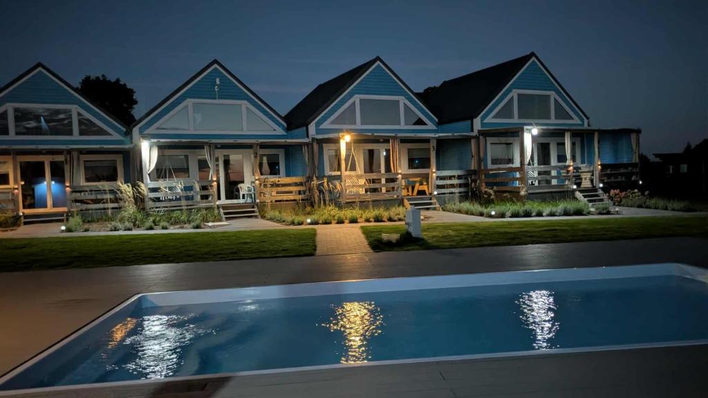 a house with a swimming pool at night at Domki Rekreacyjne "Błękitne Wzgórze" in Żałe