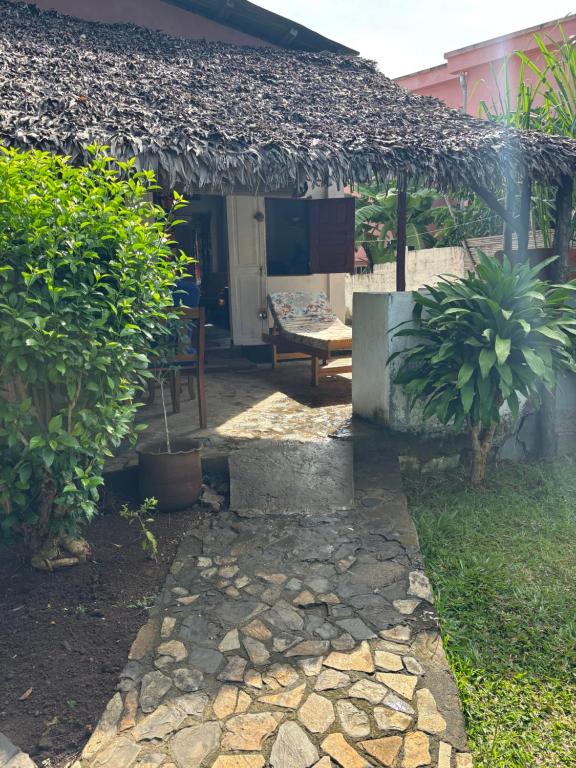 a house with a stone walkway in front of it at Maison Baby plein centre in Ambatoloaka