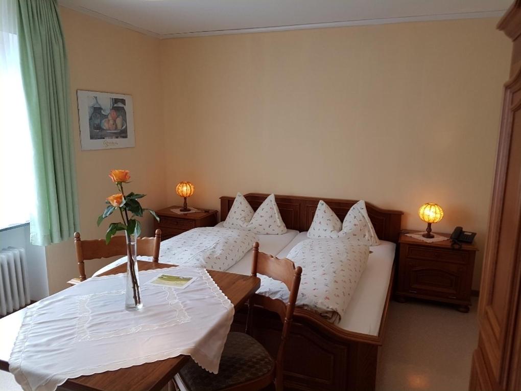 a room with a bed and a table with flowers on it at Gasthaus Decker in Mittenaar