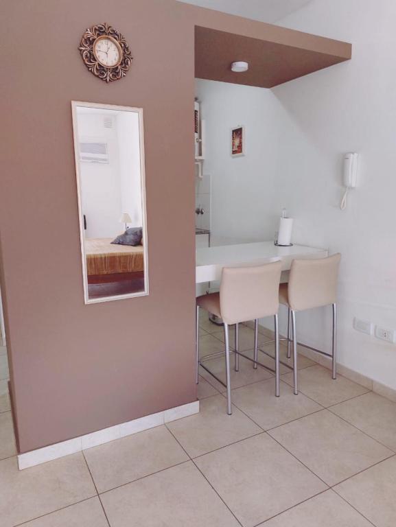 a dining room with a mirror and a table and chairs at Bahia Rental 11-Departamento x dia con cochera in Bahía Blanca