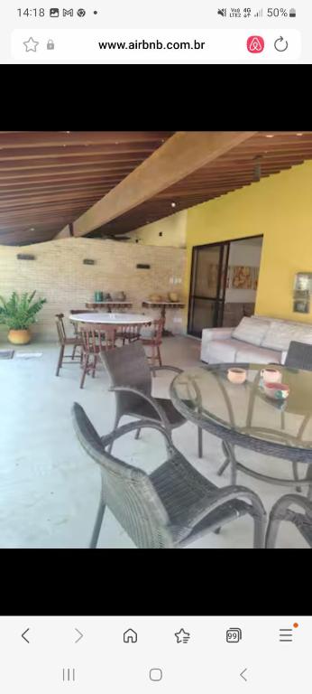 a picture of a living room with tables and chairs at Casa 4 suites in Camaçari