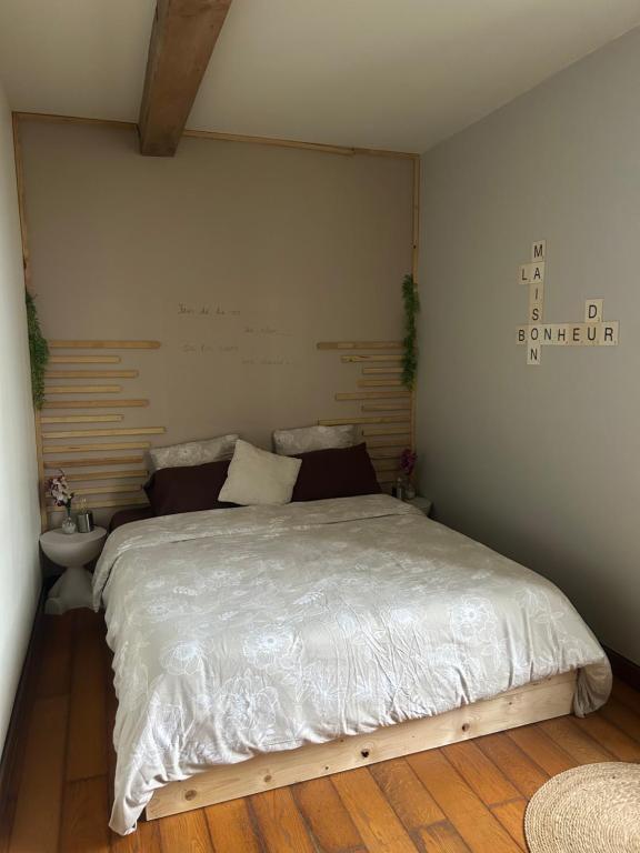 a bedroom with a large bed with a wooden floor at La maison du bonheur 17 in Marans