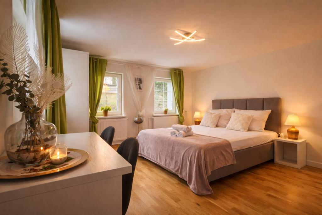 a bedroom with a bed and a table with a vase at Domek Przy Termach in Jelenia Góra