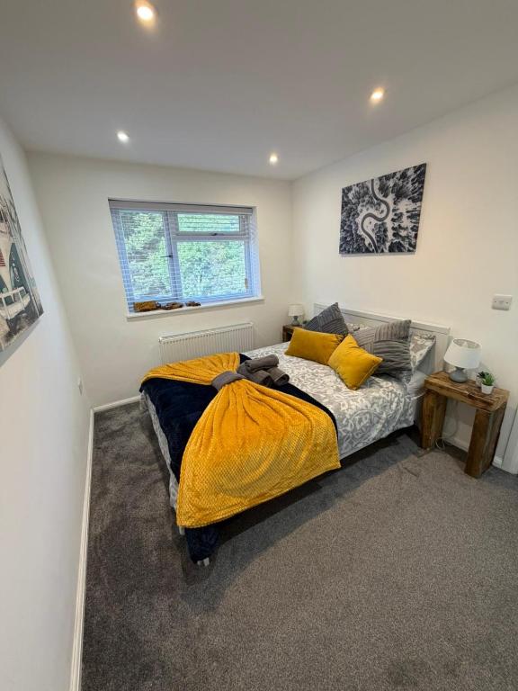 a bedroom with a bed with a yellow blanket on it at Stylish Charming London Flat Ruislip -Free Parking in Ruislip