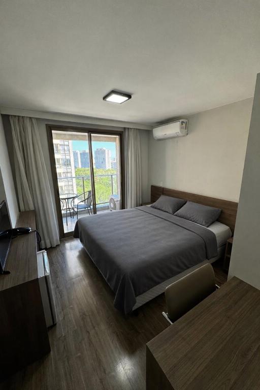a bedroom with a bed and a large window at Suíte Master Rio de Janeiro Próximo ao Rio Centro 9 Andar! in Rio de Janeiro
