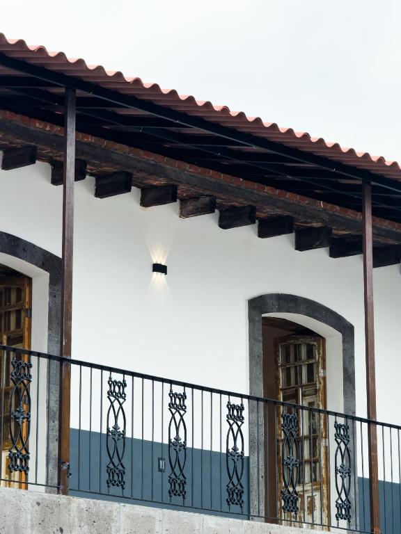 a white building with a balcony with two doors at Casa Bravo in Toluca
