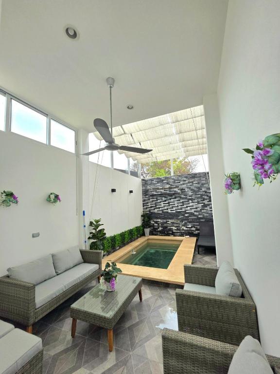 a living room with a couch and a swimming pool at Sweethome Mérida in Mérida