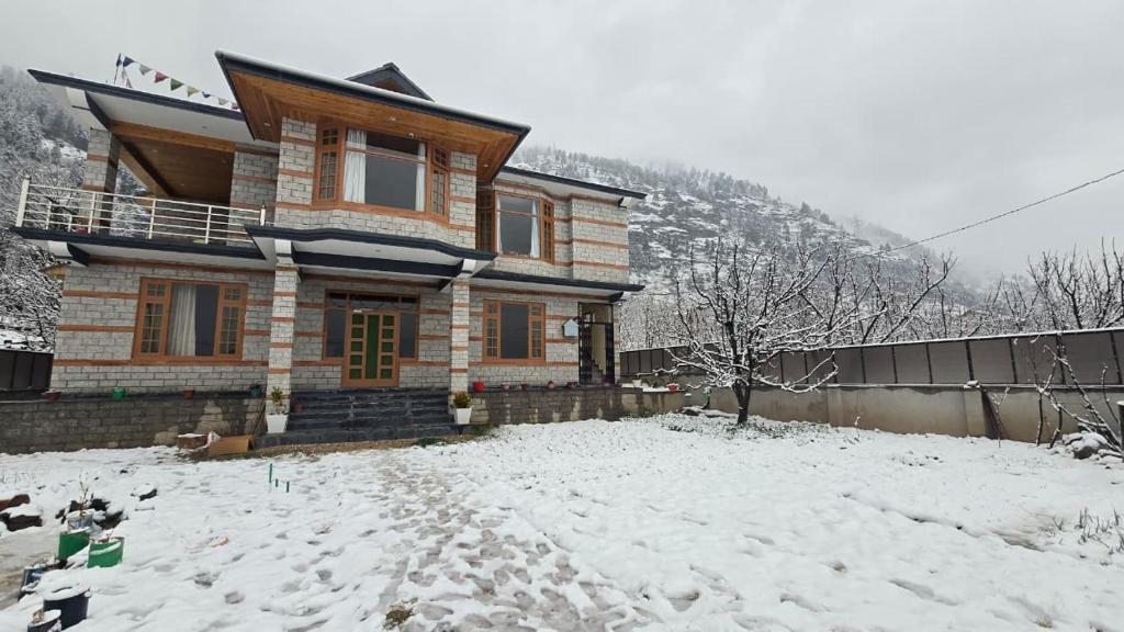a house with snow on the ground in front of it at Aashvika Homes in Katrain