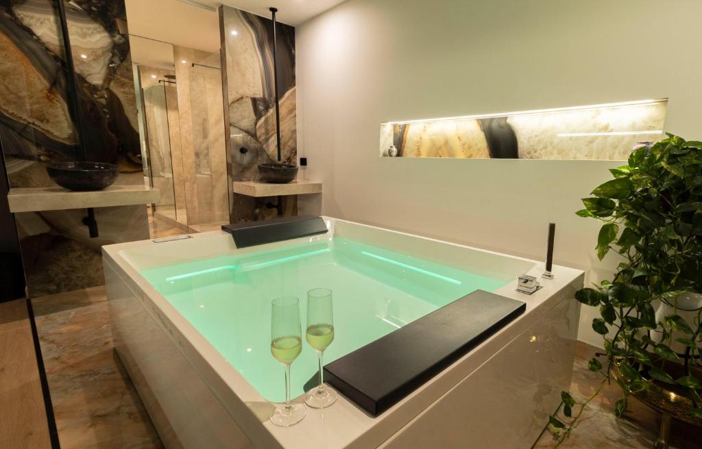 a bath tub with two wine glasses in it at Flá Suite Castello in Cagliari