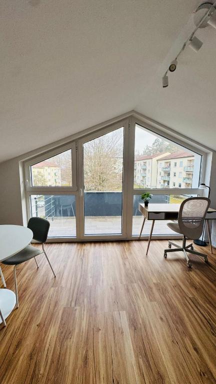 an empty room with a table and chairs and windows at Luxury Apartment in Böblingen in Böblingen