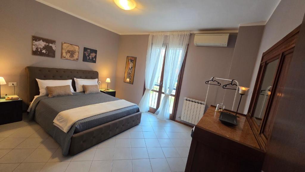 a bedroom with a bed and a desk and a window at Al Melograno - Villetta - Gussago - Franciacorta in Gussago