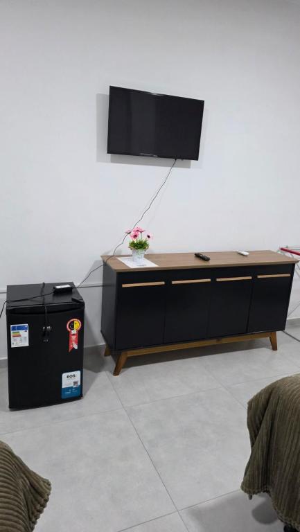 a black desk with a television on a wall at Trilhas do Araguaia in Aruanã
