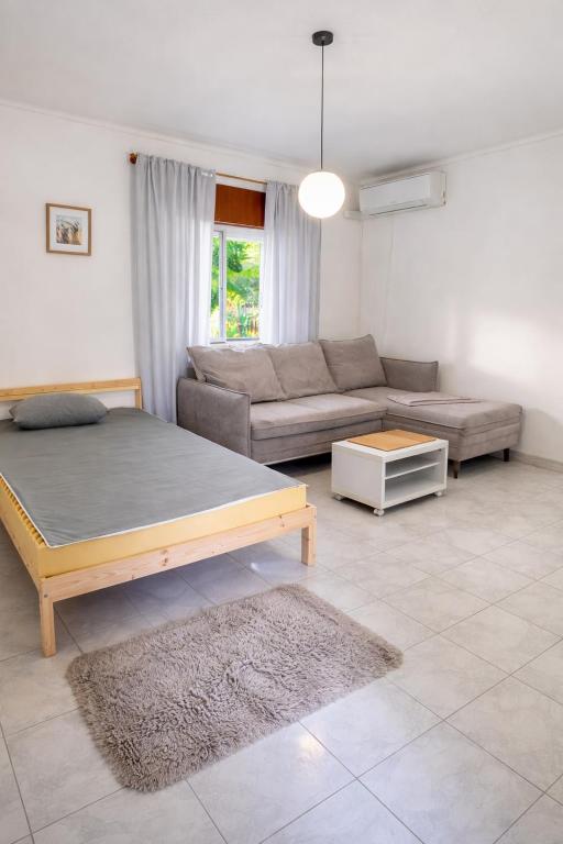 a living room with a bed and a couch at Private Room in Corroios 15 Minutes from the Beach - Quarto Privado em Corroios com Fácil Acesso à Praia e Lisboa in Corroios