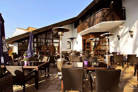 a restaurant with tables and chairs on a patio at Rooms by Ruhrpadel in Gladbeck