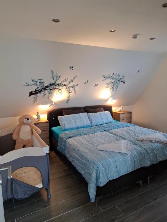 a bedroom with a bed with a teddy bear on it at Ferienwohnung bei Rheine Neubau 2026 mit Klima Terrasse ruhige Lage in Neuenkirchen