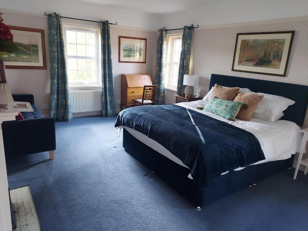 a bedroom with a large bed with blue sheets and pillows at Hawks Nest in Selkirk