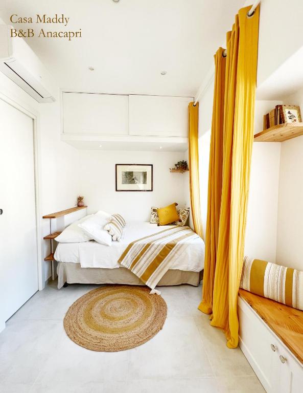 a bedroom with a bed with yellow curtains at Casa Maddy Anacapri Yellow Room in Anacapri