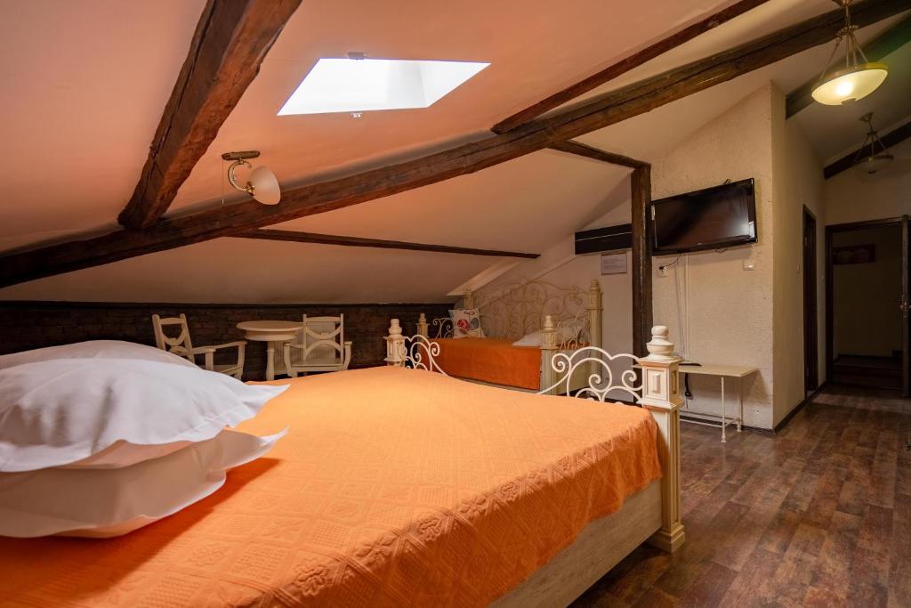 a bedroom with a bed with an orange bedspread at Residenza Dutzu-Boutique Hotel in Brăila